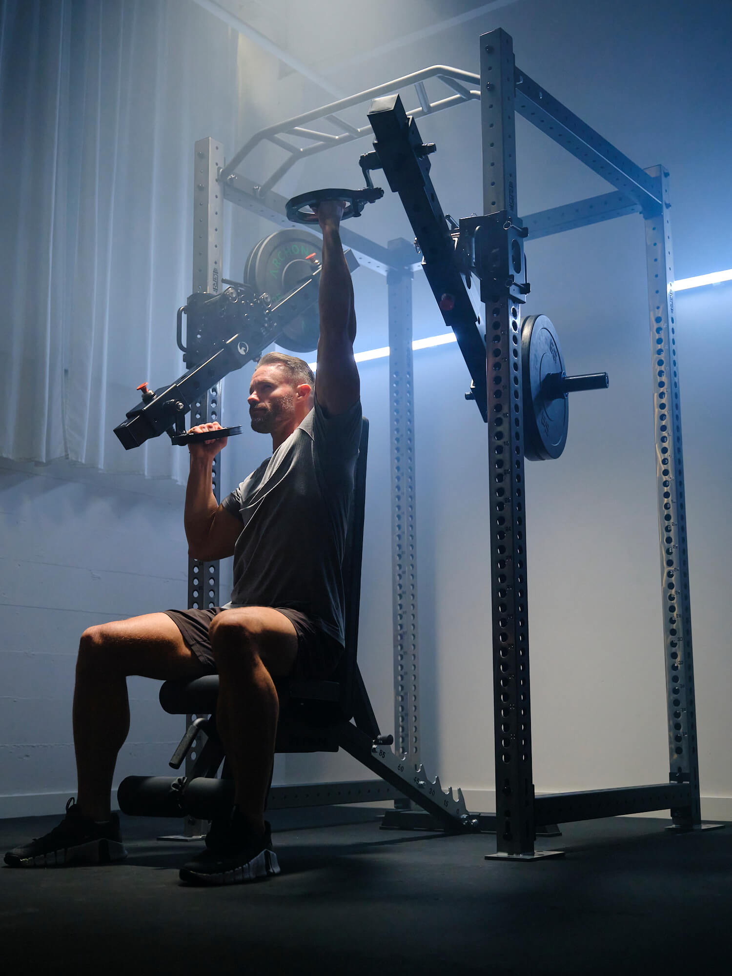 Man using RVL Strength equipment for alternating pull-downs on his weight rack